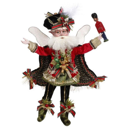 bearded fairy wearing red and black velvet cape and matching hat, holding a small nutcracker.