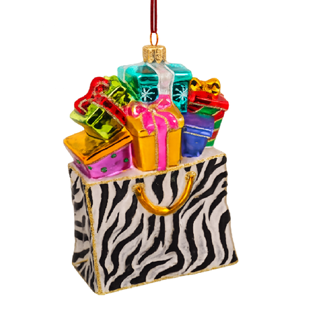 Blown glass ornament of zebra print shopping bag full of gifts.