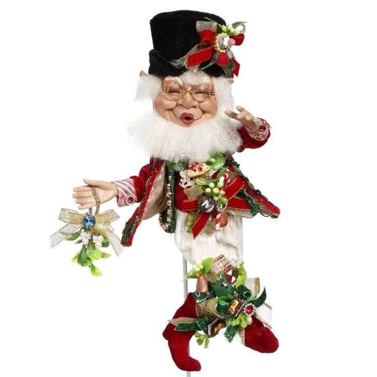 bearded elf wearing black top hat, red jacket and boots. His whole outfit is adorned with mistletoe sprigs