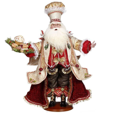 Decorative figure of a Santa Claus in an ornate chef inspired outfit with a white background