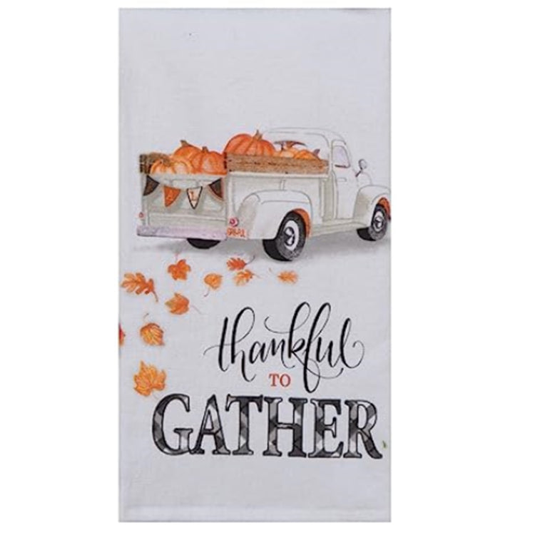 Folded white kitchen towel with White Truck with Pumpkins and the wording "thankful to GATHER"