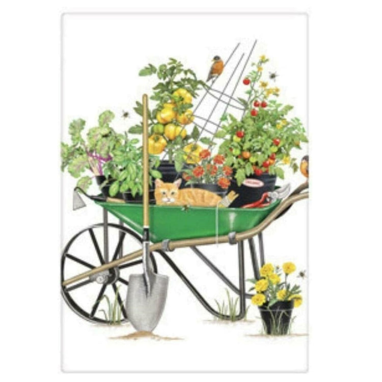 White flour sack towel with image of green wheelbarrow filled with tomato plants and an orange cat.