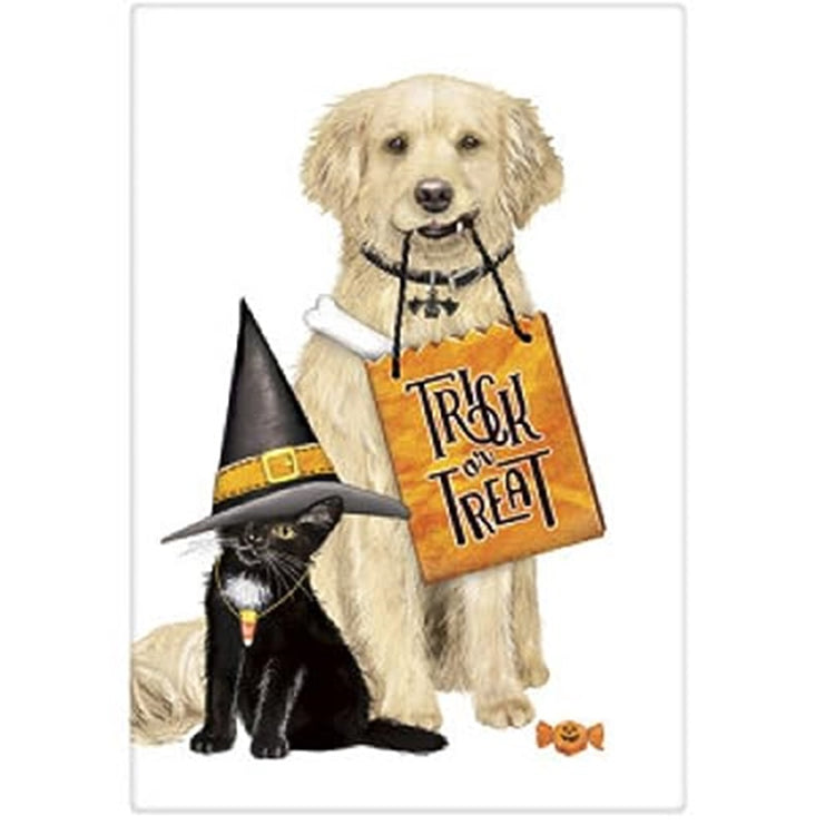 White kitchen towel with a tan dog carrying a bag that says trick or treat and a black cat wearing a witches hat.