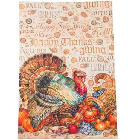 Rectangle shaped towel in shades of orange and brown  Turkey design standing by a cornucopia. Background printed with words harvest, happy fall, giving, happy fall yall, etc.