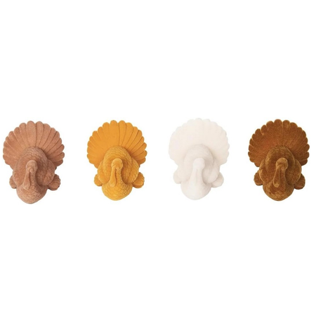 Four decorative figurines shaped like turkeys in different colors on a white background