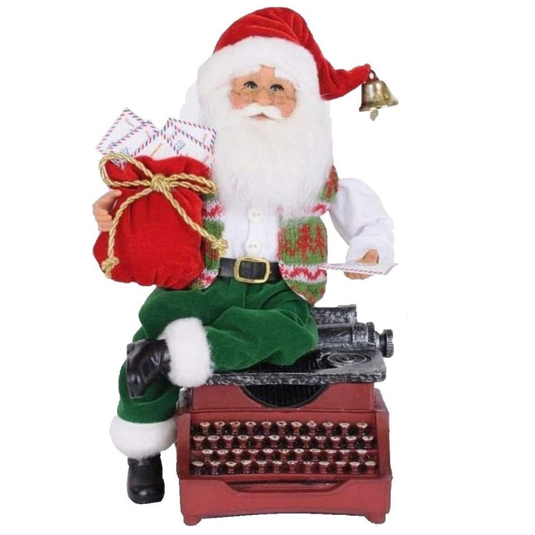 Santa figurine sitting on top of a typewriter, holding a red sack full of mail.