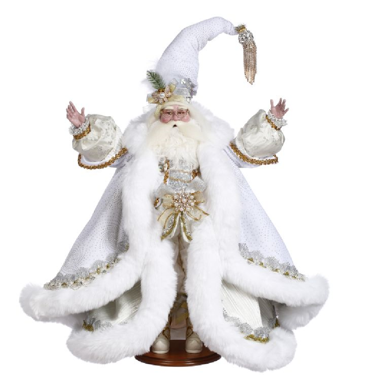 santa in a double layered, long white coat with fur trim, and gold embellishments, his white hat also has a gold tassel at the end.