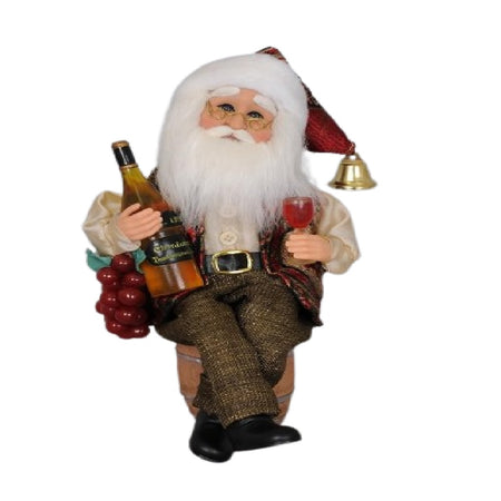 santa claus figurine holding a wine bottle and sitting on a wine cask.