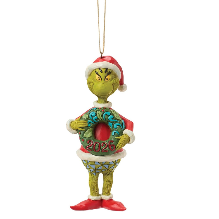 A Grinch Christmas ornament featuring the Grinch wearing a red Santa hat and a green wreath with '2026' written on it, hanging against a plain white background.