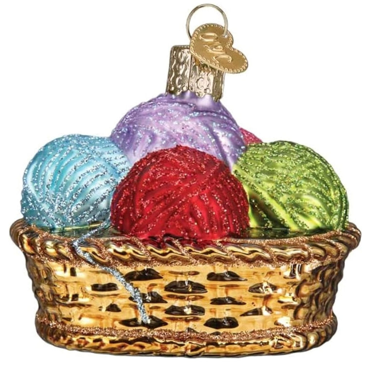 blown glass ornament of a woven basket full of different color balls of yarn.