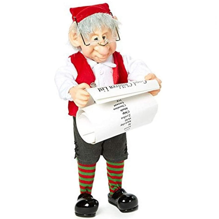 Elf like figurine standing.  He is checking Santa's list. He wears a red cap, a red vest, green shorts with red and green striped socks and black shoes.