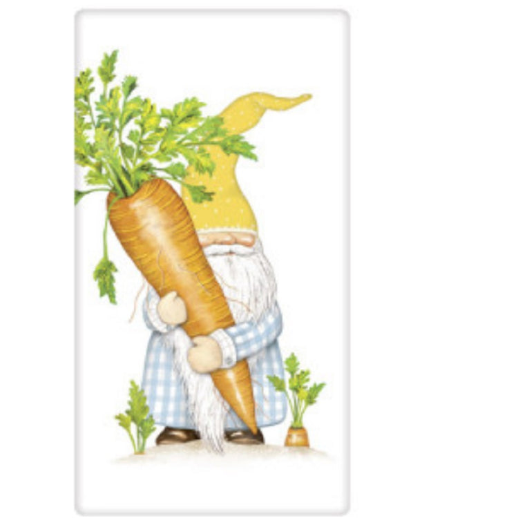 White kitchen towel with a gnome holding a giant carrot. The gnome wears and blue and white full length robe and there are 2 carrots growing in the ground at his feet. The gnome wears a tall pointy yellow hat.