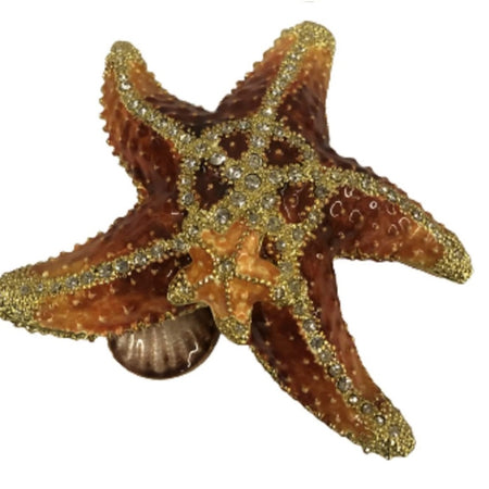 Starfish shaped jeweled box. Smaller starfish is on the top and a shell peaks out underneath. The starfish is shades of tan with gold glitter and crystal accent