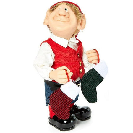 Standing Elf figurine.  He wears a red hat, red vest over a white shirt and green pants.  He holds 2 stocking, 1 red and black check and 1 green and black check.