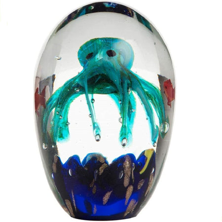 Clear oval glass paperweight.  Inside is a turquoise octopus design over blue ocean bed with red fish swimming around