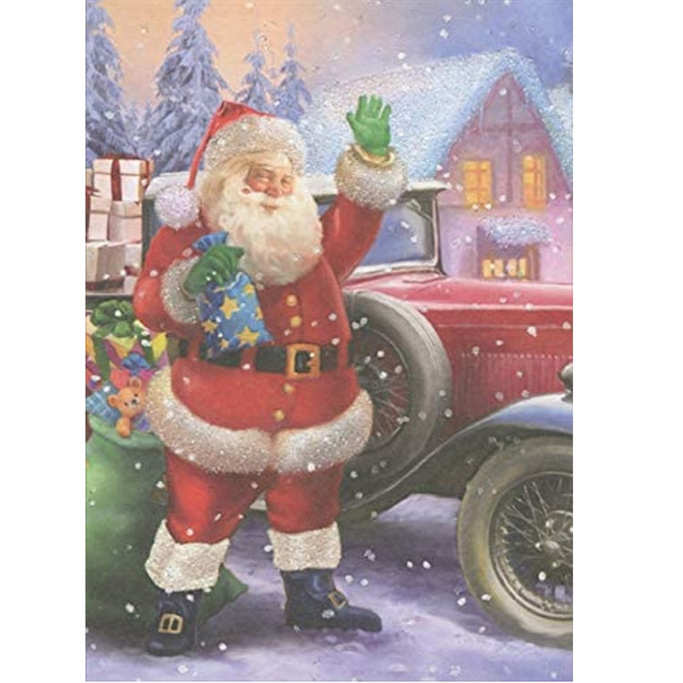 Christmas card shows Santa Claus holding a gift standing outside a home in a snow scene. He stands beside a red vintage car waving.  Sack of gifts by his feet.