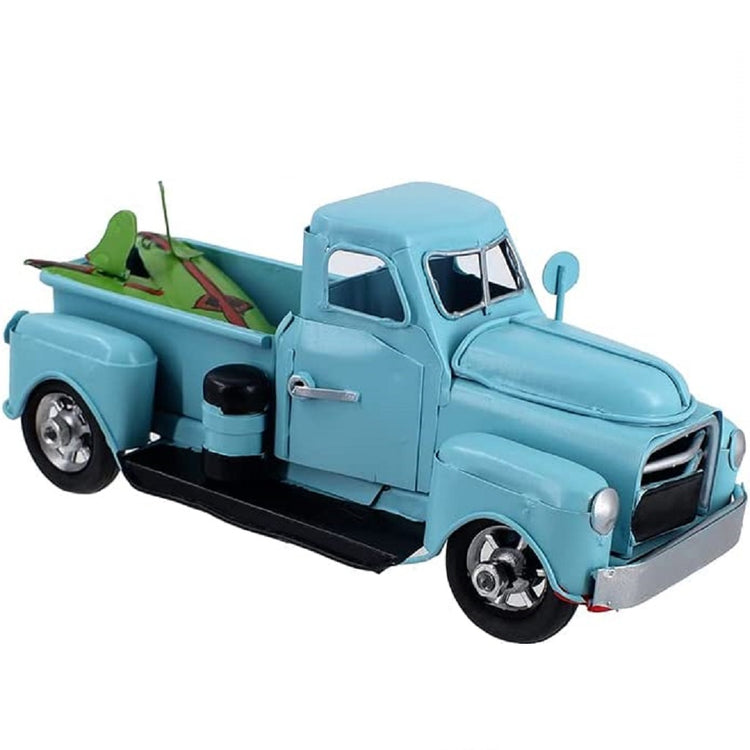 Side view of a replica or model truck. Blue with 2 green surfboards in the truck bed.