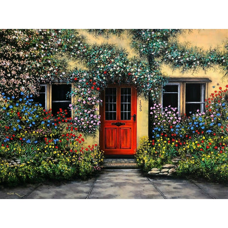 Light yellow building with bright red door, vines with flowers cover the walls, and there is blue, yellow and red flowering bushes by the door. This is the image on this puzzle.