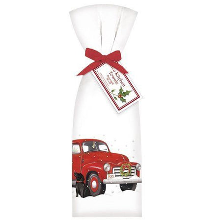 2 white towels tied with red ribbon. Towel shows a red truck in the snow and a black dog.