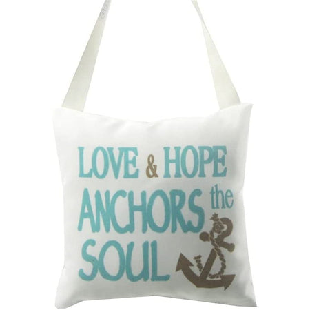 White pillow that says "Love & Hope anchors the soul". 