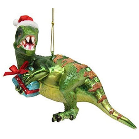 Blown glass green dinosaur ornament holding a blue and red gift, wearing a Santa hat.