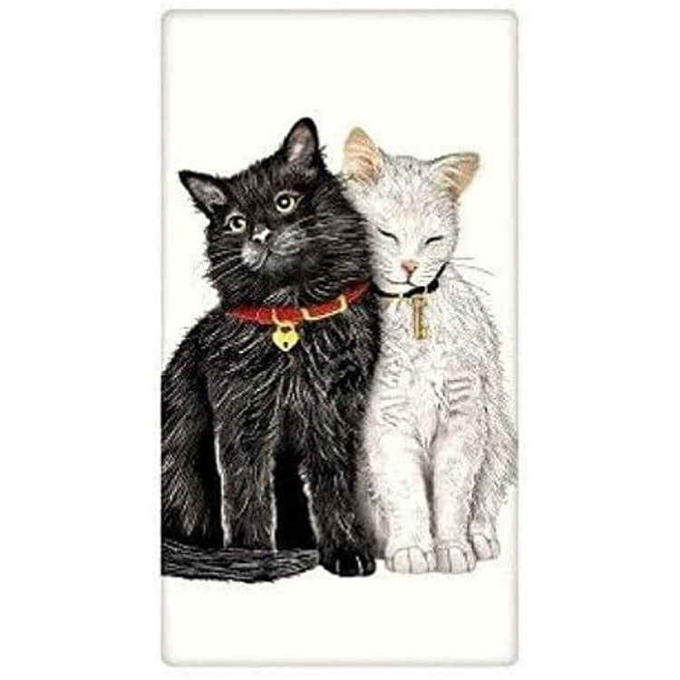 1 black kitten cuddling 1 white kitten. Both wearing collars 1 with a lock charm & 1 with a key charm.