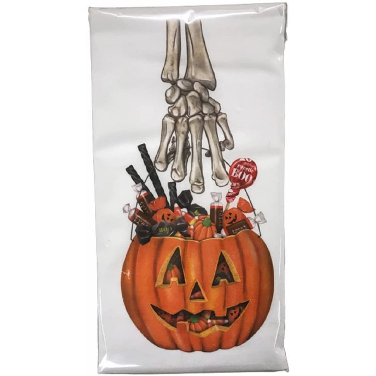 white flour sack towel with design of a skeleton hand holding a jack o lantern shaped candy bucket full of candy.