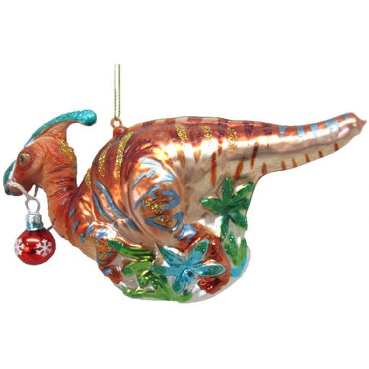 Orange dinosaur with gold glitter stripes on its back, a red ornament in its mouth, & foliage.