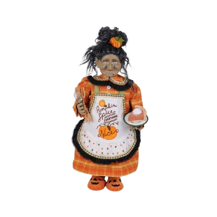 Granny witch with an orange plaid dress & pumpkin pie in her hand.