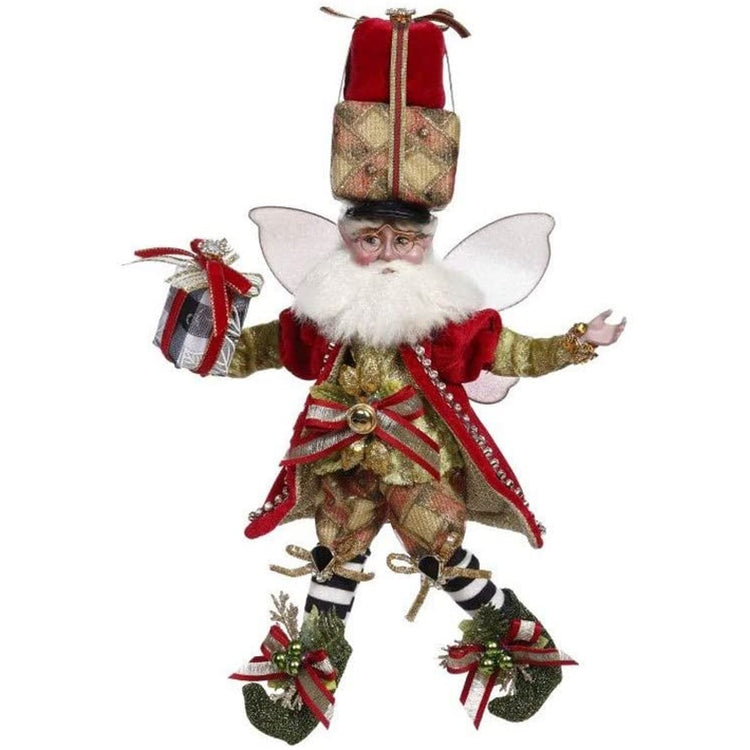 bearded fairy with two presents on top of his head and one in his hand. He is wearing a gold shirt, red coat, and red and gold checked shorts.