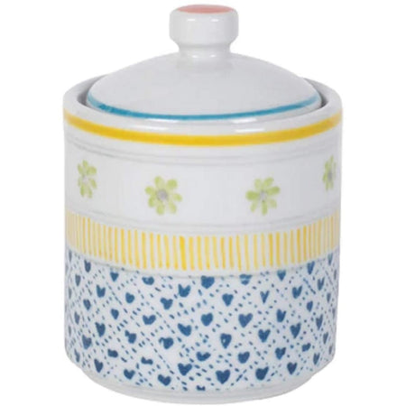 White sugar bowl with blue hearts, green flowers, yellow stripes, & a pink dot on top.