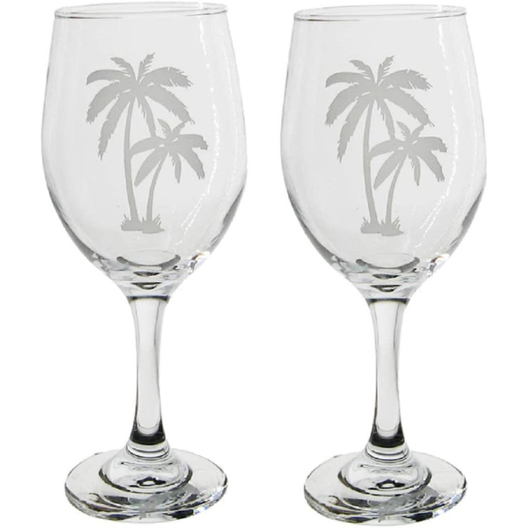 2 glass wine glasses with palm tree designs etched into the glass.
