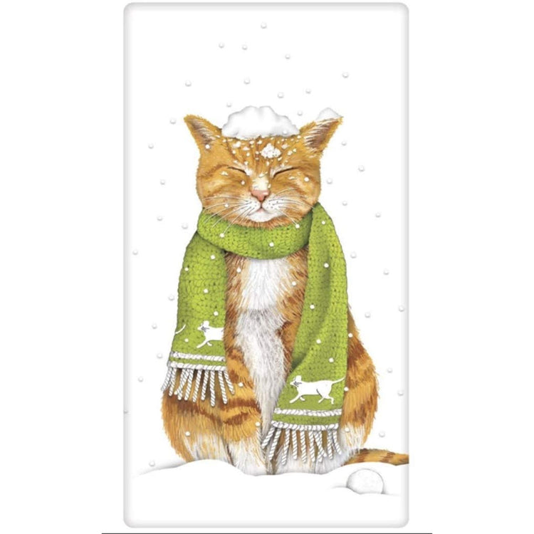 White flour sack kitchen towel imprinted with cat in the snow wearing a green knit scarf.