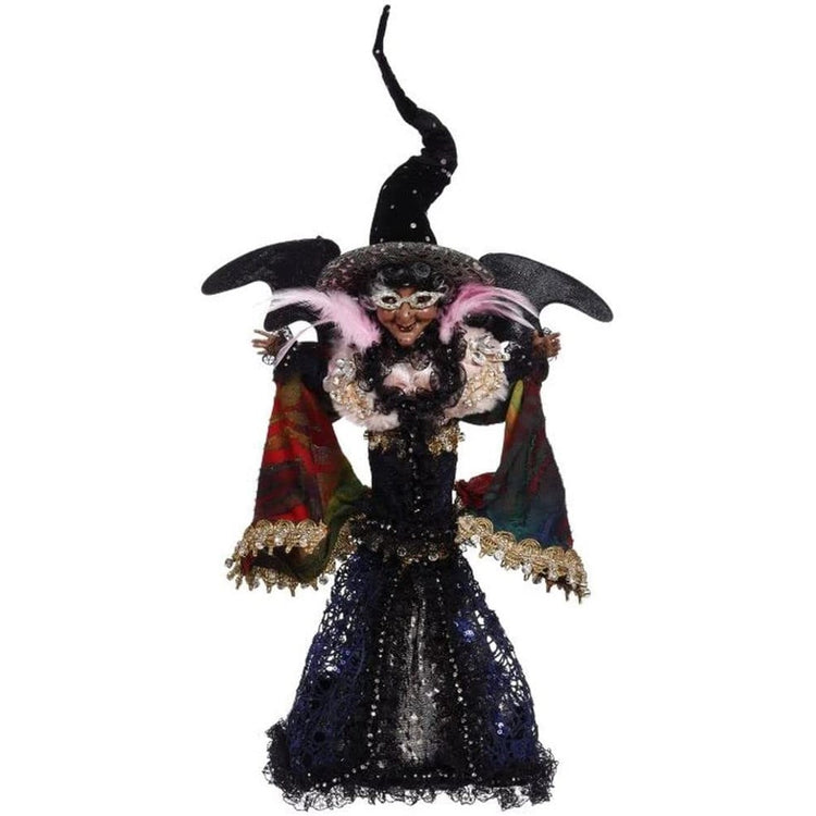 Witch figurine wearing long blue & black skirt rainbow shawl and tall black hat, she also has black wings.