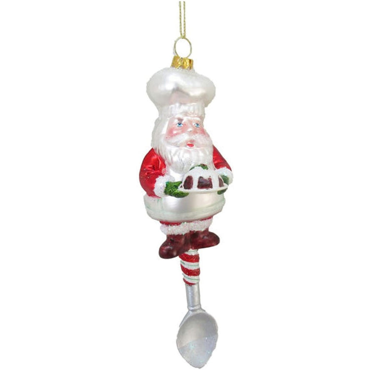 Blown glass ornament shaped like a spoon, the handle is santa in a chef's hat holding a cake.