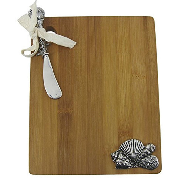 Rectangle shaped wood cutting board with silver metal seashell icons and ribbon tied shell spreader.