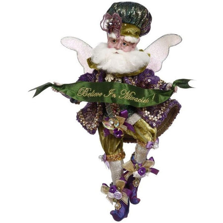 Bearded fairy in purple coat & shoes, and gold pants, collar and the hat is gold, green and purple. Holding green ribbon that says "Believe in Miracles!"