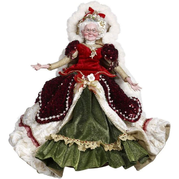 Mrs. Claus in a red velvet top with white cape and green skirt