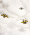 White scarf with yellow & black bumble bees scattered on it.