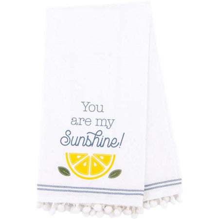 white towel with blue stripe around the edge, and white pom poms, has the words "you are my sunshine" in blue with a lemon slice.