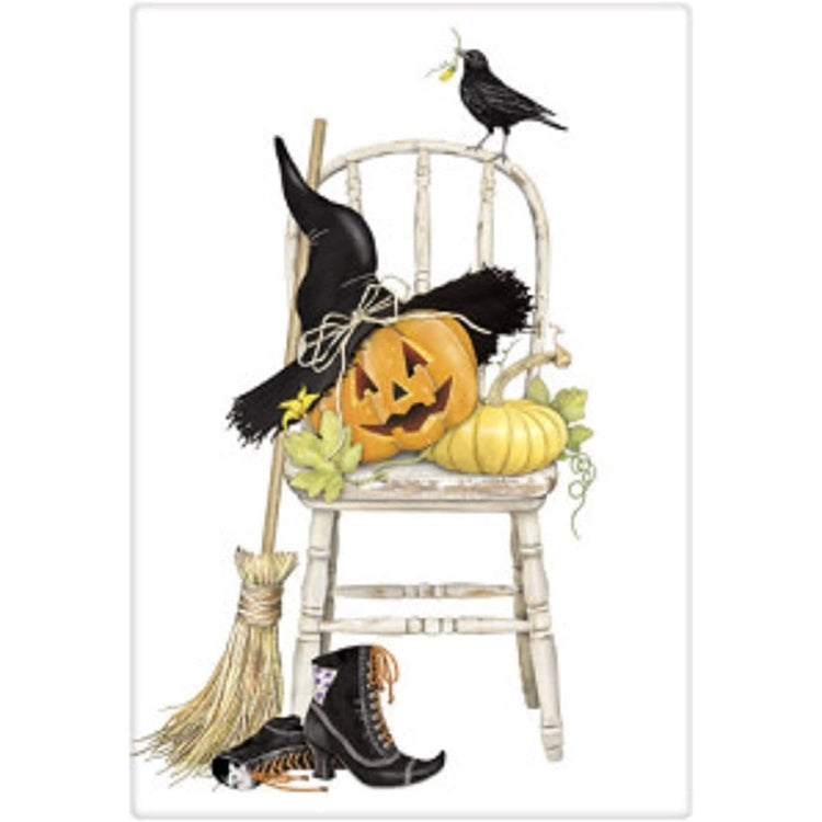 Chair with pumpkins wearing a witch hat, boots & a broom.