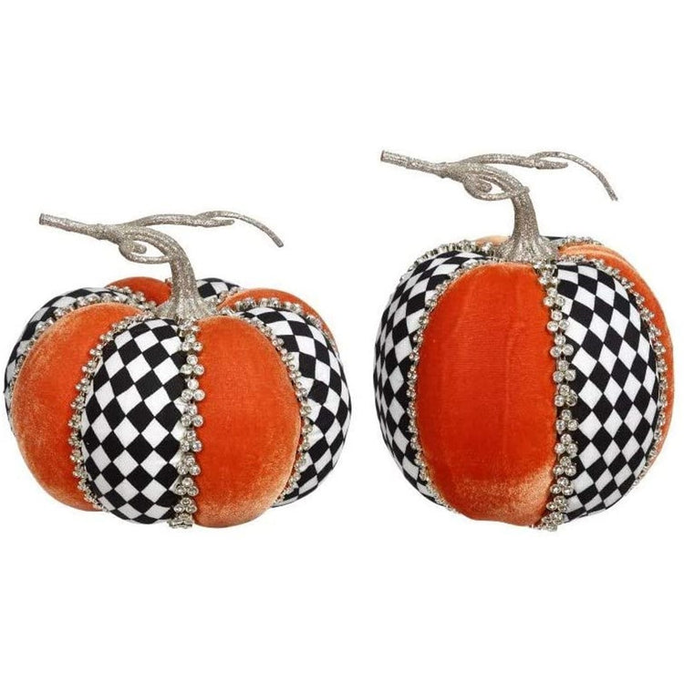 Two pumpkins made up of orange velvet and black and white harlequin fabric separated by silver rhinestones.