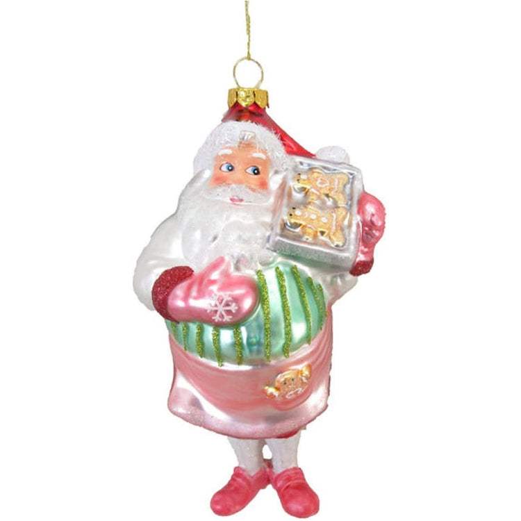 Blown glass Santa ornament. He is in a pink apron and mittens holding a tray of gingerbread cookies.