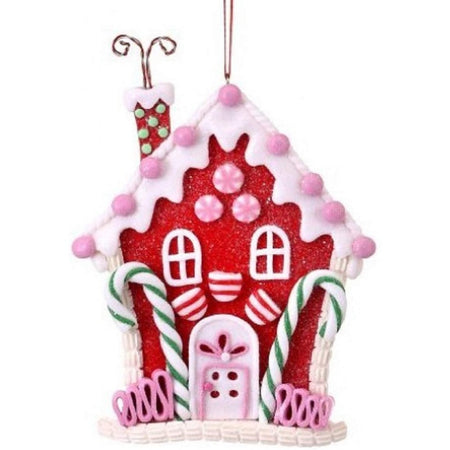 Red candy house decorated with pink, white & green candies.