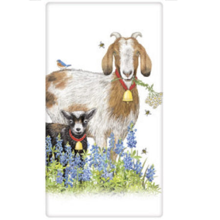 White dish towel with 2 goats standing in a field of blue bonnet flowers.  The tall goat is tan and white he has a stem of white flowers in his mouth, a bee by his head and a bird on his back. The smaller goat is black and white, both have bells around their neck.