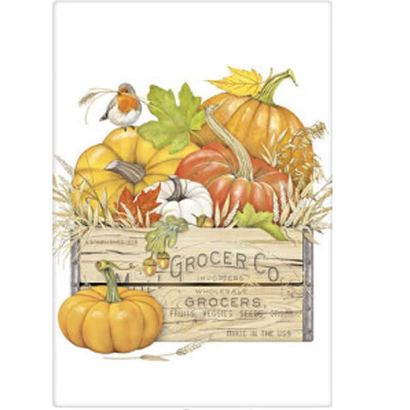 White dish towel with a crate full of pumpkins and one pumpkin in front of the crate.  The crate says Grocer Co. and smaller text that fades out wholeale grocers fruits vegies seeds ... the pumpkins are white and shades of orange wiht some leaves and wheat with a single bird.