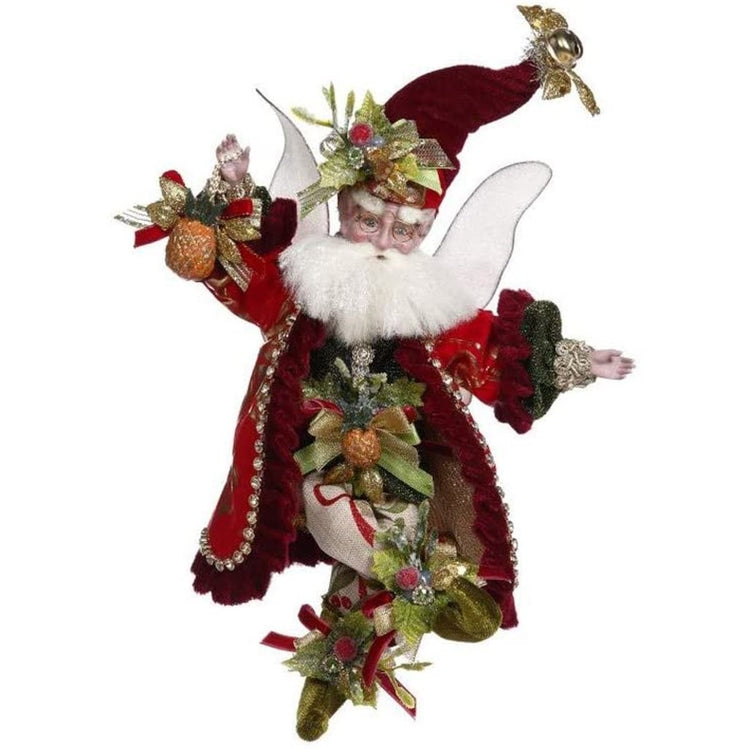 White bearded fairy with a red velvet coat & hat on. He is holding an embellished pineapple.