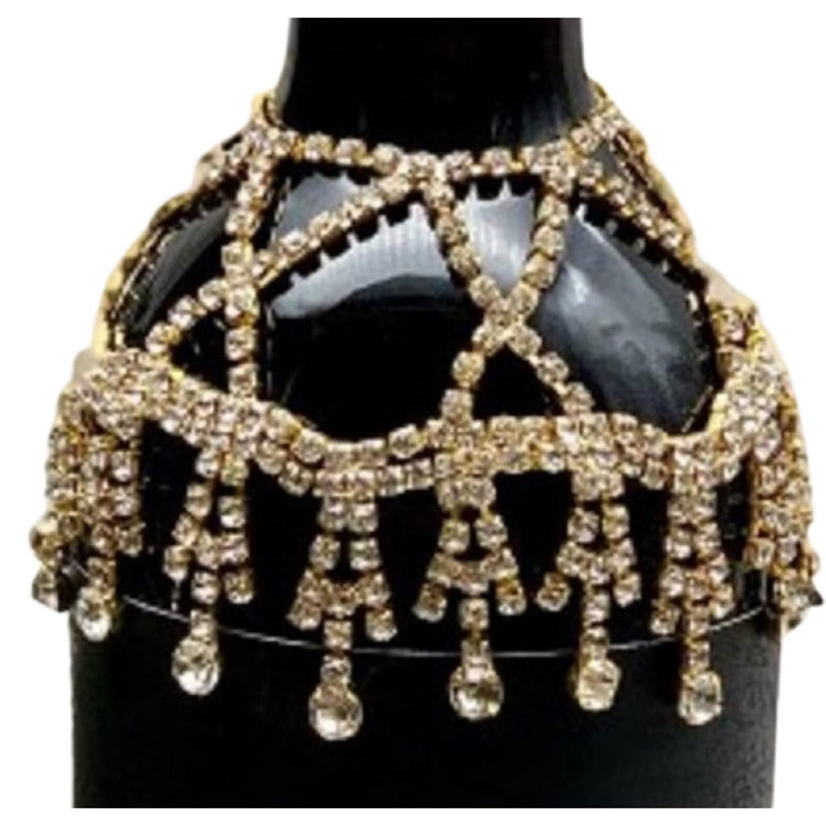 Gold and Jeweled wine collar draped over the neck of a black bottle.