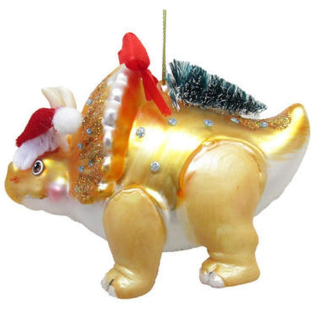yellow blown glass triceratops ornament with santa hat, red ribbon, and christmas tree. 