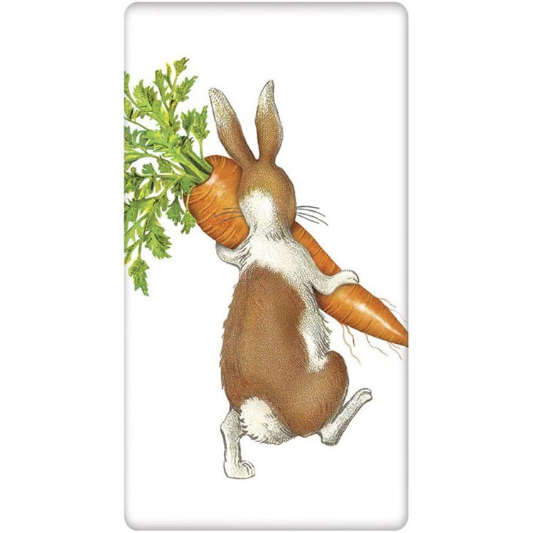 White towel with  a white and brown rabbit walking away carrying a large carrot.
